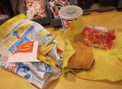 McDonald's dollar menu items including fries, burger, and sauce packet on yellow wrapper