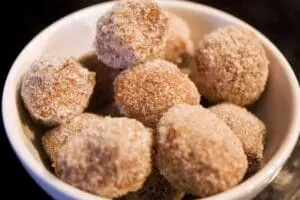 Cinnamon sugar-coated fried dough balls in a white bowl