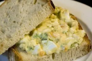 Organic egg salad sandwich on white bread with herbs