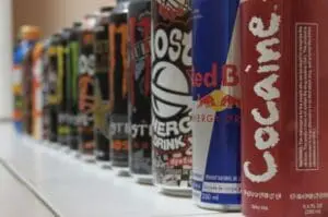 Row of colorful energy drink cans lined up on a shelf