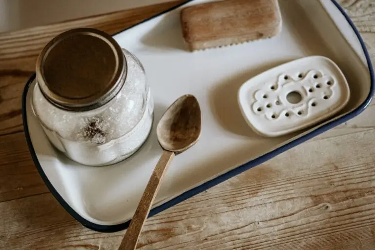 Image of epsom bath salts on a white tray with a spoon and a bath brush. There are many benefits to taking a bath with epsom salts