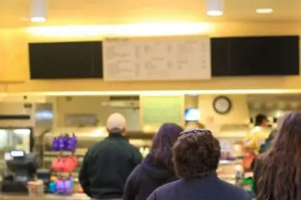 People waiting in line at a fast food restaurant counter