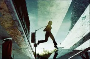 Woman jumping over puddle