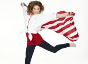 Woman in red and white striped shirt kicking energetically against white background