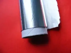 Rolled aluminum foil tube on red background