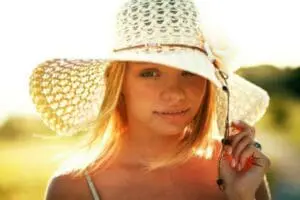 Woman wearing a wide-brimmed straw hat in sunlight outdoors