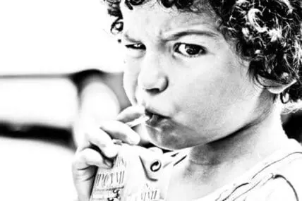 Child with hand near mouth, appearing thoughtful or contemplative