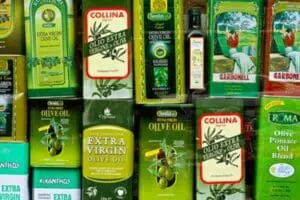 Various bottles of extra virgin olive oil brands arranged on shelves