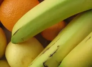 Fresh bananas and oranges in a pile
