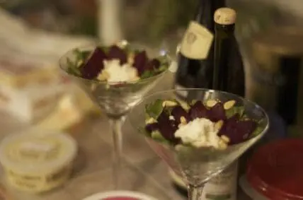 Elegant plated beet and goat cheese salad with beer in the background