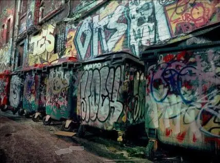 Graffiti-covered shipping containers and walls in an urban alley