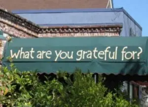 Green awning with "What are you grateful for?" text on storefront