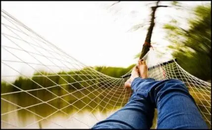 Person relaxing in a hammock overlooking a serene lake