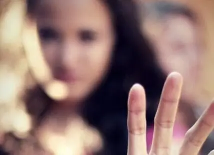 Close-up of fingernails with blurred figures in background
