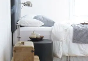 Modern bedroom with minimalist nightstand, candle, and decorative pillows