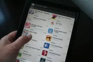 Person holding smartphone displaying health and fitness apps in app store