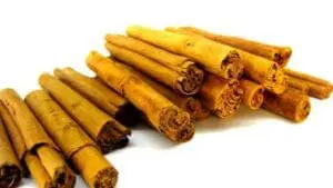Bundles of dried cinnamon sticks arranged on a white background