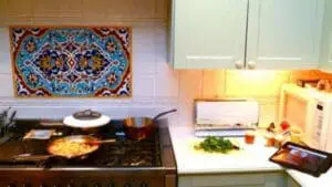 iPad on kitchen counter next to fresh vegetables and cooking ingredients
