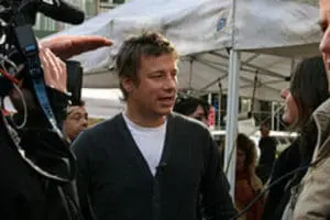 Jamie Oliver being interviewed under a tent at an outdoor event