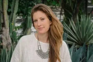 Jessa Blades wearing a cream linen top and statement necklace in a garden setting