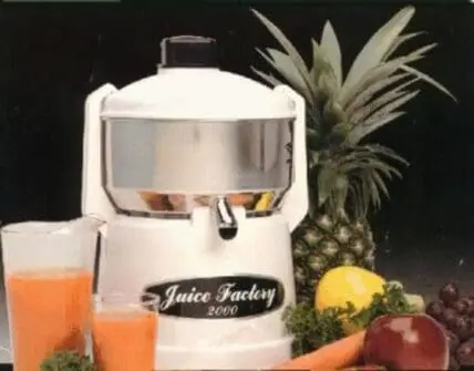 Juice Factory 2000 juicer with fresh produce and glasses of juice on black background