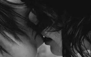 Black and white close-up of two people kissing