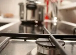 Close-up of a stainless steel kitchen sink with cleaning cloth and spray bottle.