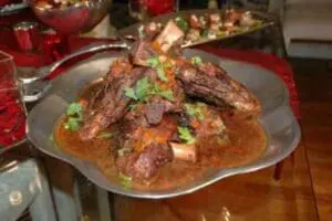 Braised lamb shanks with mushrooms and fresh herbs on mashed potatoes