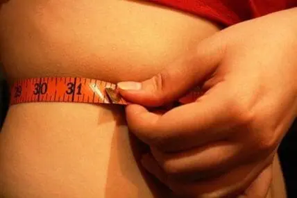 Person measuring their arm circumference with a tape measure