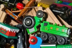 Assorted toy cars and vehicles scattered on a wooden surface