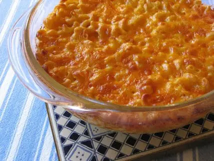 Baked mac and cheese in a glass casserole dish with golden-brown cheese topping