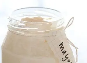 Homemade mayonnaise in a glass jar with label