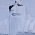 Melting glacier face with water streaming down, representing climate change effects in Norway