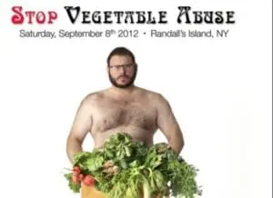 Shirtless man holding fresh vegetables at a "Stop Vegetable Abuse" event on Randall's Island, NY