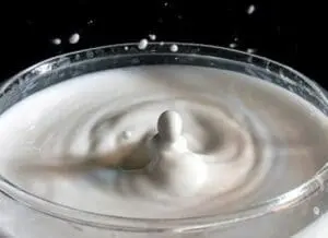 Milk splashing in a bowl with droplets suspended in air