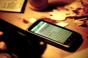Smartphone displaying a healthy eating app on a wooden table with recipe cards