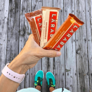 Person holding three LARABAR and FlapBar energy bar packages