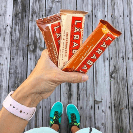 Person holding three LARABAR and FlapBar energy bar packages