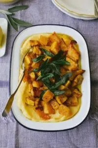 Creamy polenta topped with roasted butternut squash and crispy sage leaves