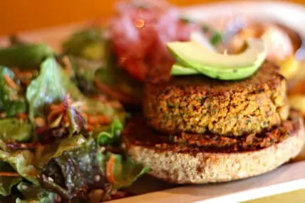 Vegetable patty burger on whole grain bread with avocado and greens