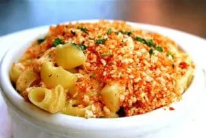 Elbow pasta with breadcrumb topping and fresh herbs in a white bowl