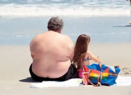 Adult and child sitting together on a beach