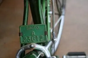 Vintage green bicycle frame with serial number tag labeled "SACTO.