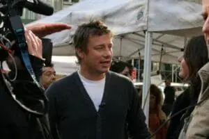 Jamie Oliver being interviewed at an outdoor event with camera crew