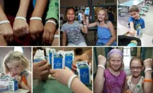 Children wearing white wristbands at a school health or nutrition event