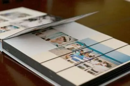 Open photo album displaying printed images arranged on white pages
