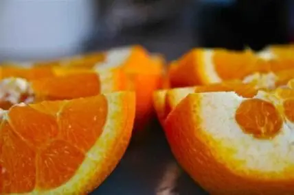 Sliced orange halves showing flesh and peel in close-up detail