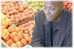 Man examining red peppers at a farmers market produce stand