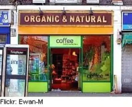 Storefront of an organic and natural coffee shop with green and red signage