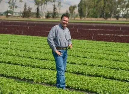 Otto Kramm standing in a lush green organic farm field
